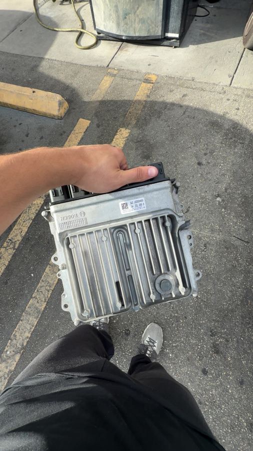 Holding a car ECU pulled from the vehicle