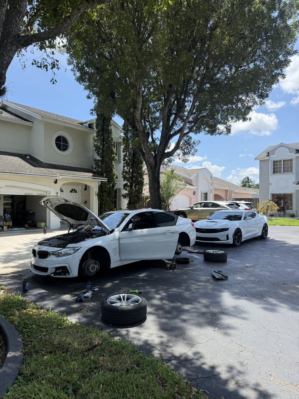 BMW with wheel removed in the driveway